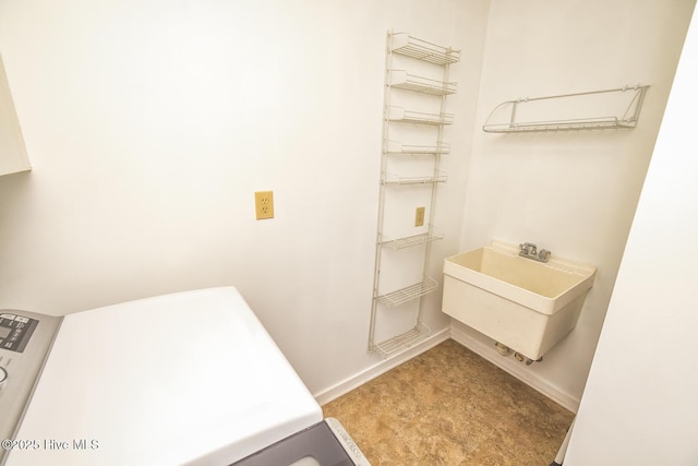 bathroom featuring baseboards and a sink