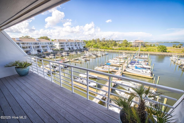 wooden terrace featuring view of marina, a water view, and a dock