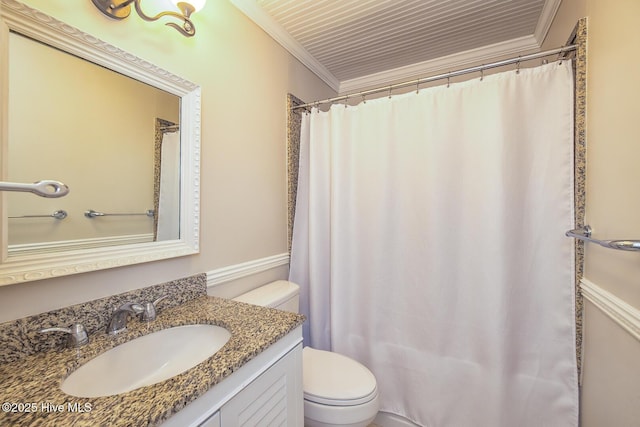 bathroom featuring toilet, vanity, ornamental molding, and curtained shower