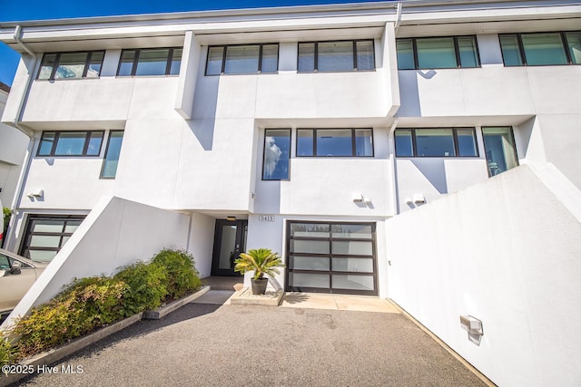 view of front of house with stucco siding and a garage