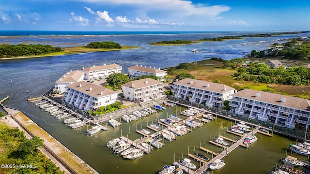 drone / aerial view of a nearby body of water, a marina, and apartment complex