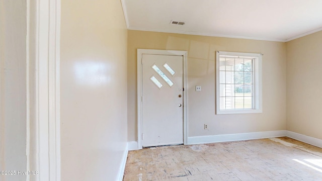 foyer entrance with crown molding and baseboards