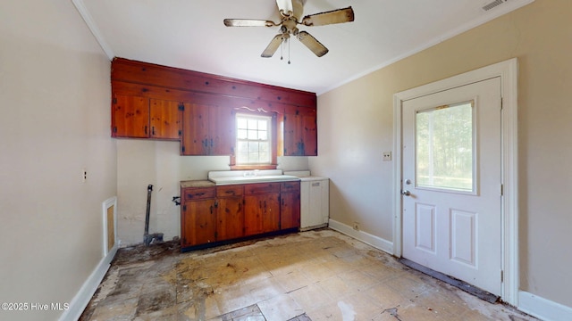 kitchen featuring crown molding, light countertops, a ceiling fan, a sink, and brown cabinets