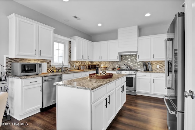 5606 Swiss Stone Ct, Wilmington, NC 28412 - kitchen featuring stainless steel appliances, decorative backsplash, a center island, dark wood-style flooring, and recessed lighting
