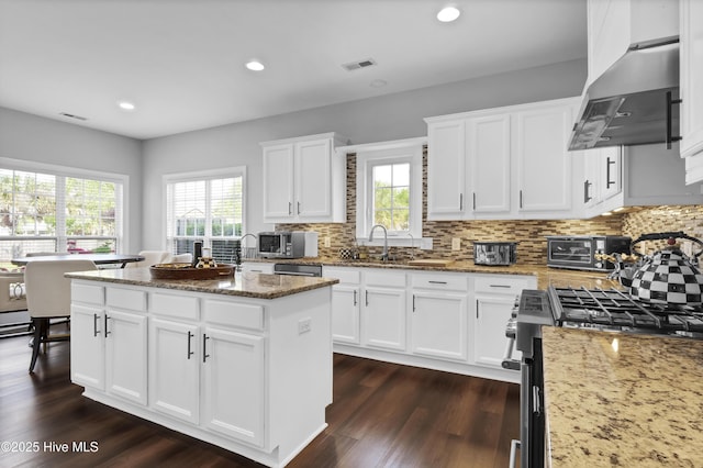 5606 Swiss Stone Ct, Wilmington, NC 28412 - kitchen with range hood, appliances with stainless steel finishes, a center island, a sink, and light stone counters