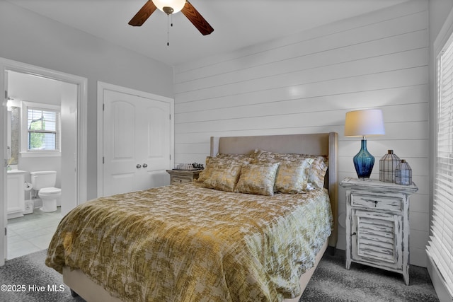 5606 Swiss Stone Ct, Wilmington, NC 28412 - bedroom featuring carpet floors, connected bathroom, wood walls, and a ceiling fan