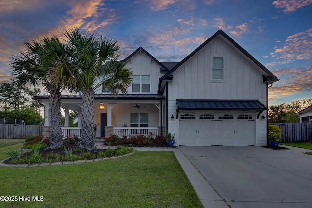 5606 Swiss Stone Ct, Wilmington, NC 28412 - view of front of property featuring an attached garage, concrete driveway, a porch, board and batten siding, and a standing seam roof