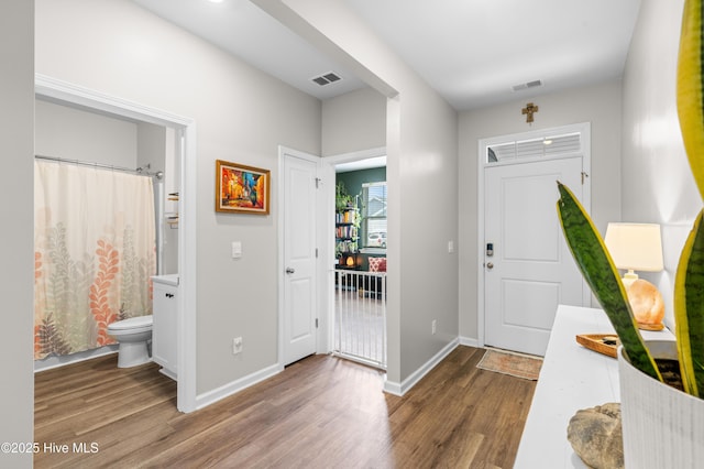 foyer entrance with wood finished floors and baseboards