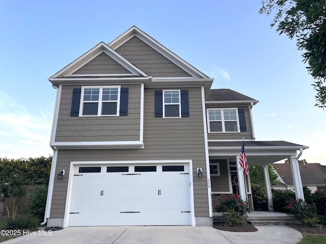 craftsman-style home featuring covered porch, an attached garage, and driveway