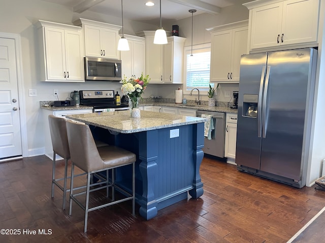 kitchen featuring stainless steel appliances, white cabinets, dark wood-type flooring, a kitchen island, and recessed lighting