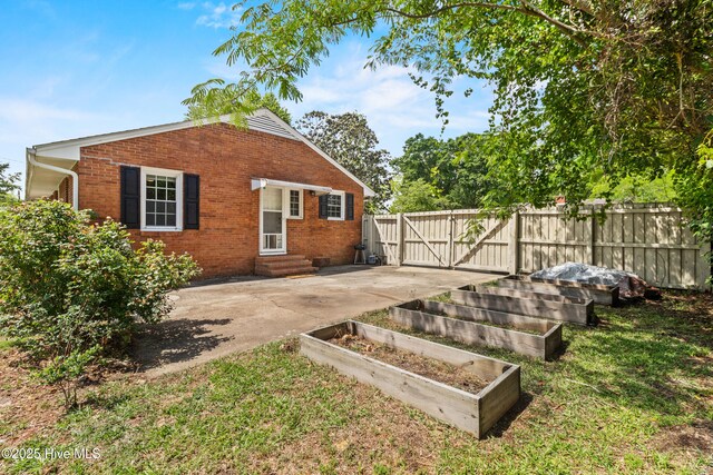 113 S Canal St, Whiteville, NC 28472 - view of home's exterior with brick siding, entry steps, a garden, and a gate