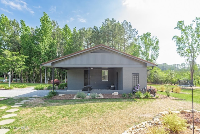 229 Rays Bridge Rd, Whispering Pines, NC 28327 - view of front of property featuring a front lawn, brick siding, driveway, a carport, and covered porch