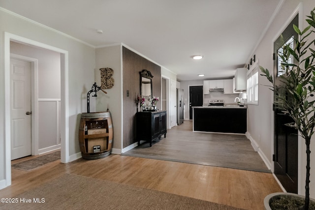 229 Rays Bridge Rd, Whispering Pines, NC 28327 - kitchen featuring light wood-style floors, under cabinet range hood, white cabinetry, a sink, and stainless steel appliances