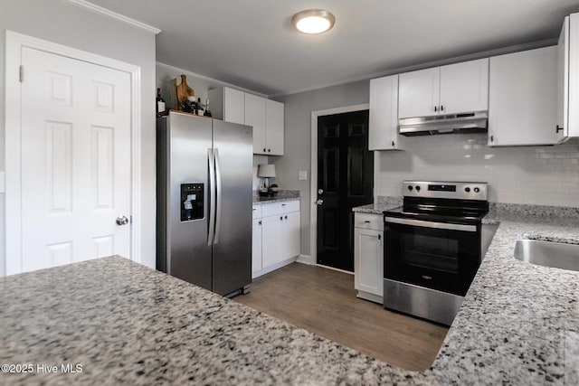229 Rays Bridge Rd, Whispering Pines, NC 28327 - kitchen featuring appliances with stainless steel finishes, under cabinet range hood, dark wood-type flooring, tasteful backsplash, and white cabinetry