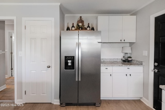 229 Rays Bridge Rd, Whispering Pines, NC 28327 - kitchen with stainless steel fridge with ice dispenser, light wood finished floors, white cabinets, and ornamental molding