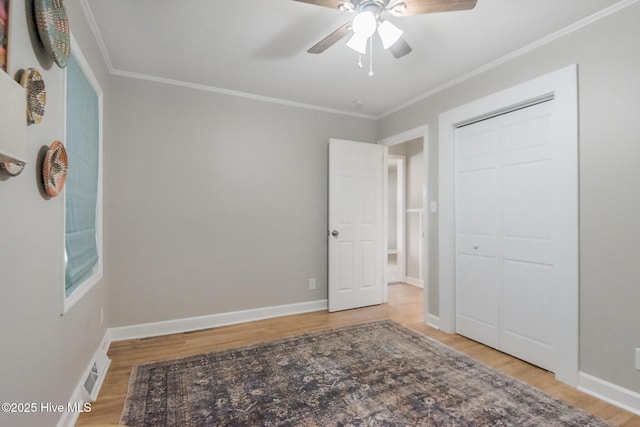 229 Rays Bridge Rd, Whispering Pines, NC 28327 - unfurnished bedroom with light wood-style floors, ornamental molding, a ceiling fan, baseboards, and a closet
