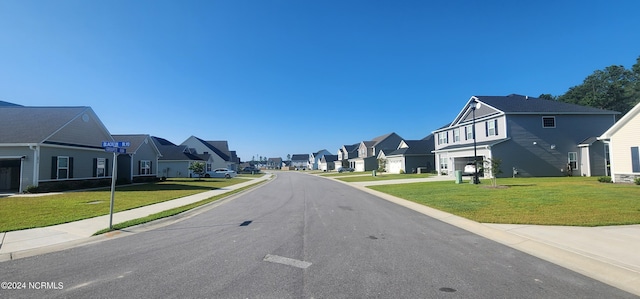 view of asphalt street with a residential view, sidewalks, and curbs