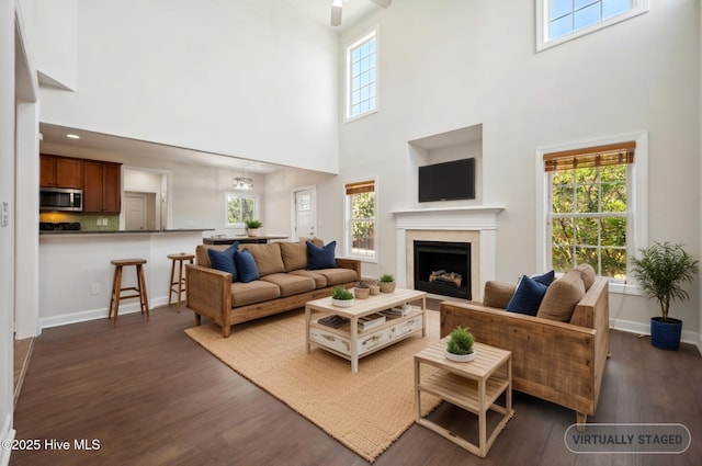 870 Wine Cellar Cir, Wilmington, NC 28411 - living area featuring a towering ceiling, dark wood-style flooring, a fireplace, baseboards, and a ceiling fan