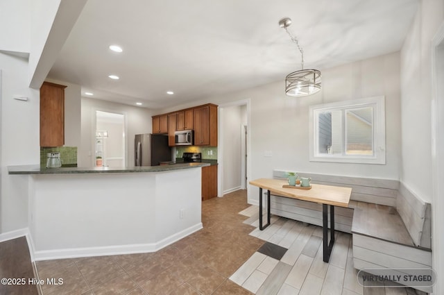 870 Wine Cellar Cir, Wilmington, NC 28411 - kitchen featuring appliances with stainless steel finishes, brown cabinetry, decorative backsplash, recessed lighting, and decorative light fixtures