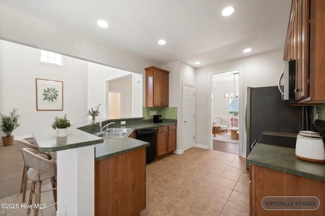 870 Wine Cellar Cir, Wilmington, NC 28411 - kitchen with black dishwasher, a sink, dark countertops, a peninsula, and tasteful backsplash