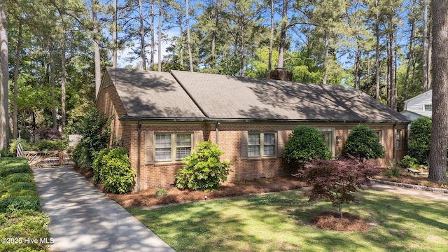 224 Westview Park Dr, Rocky Mount, NC 27804 - ranch-style house with brick siding, a chimney, a front yard, and roof with shingles