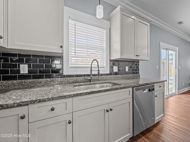 kitchen with stainless steel dishwasher, a sink, ornamental molding, wood finished floors, and stone countertops