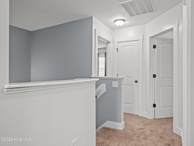 hall featuring an upstairs landing, carpet floors, and baseboards