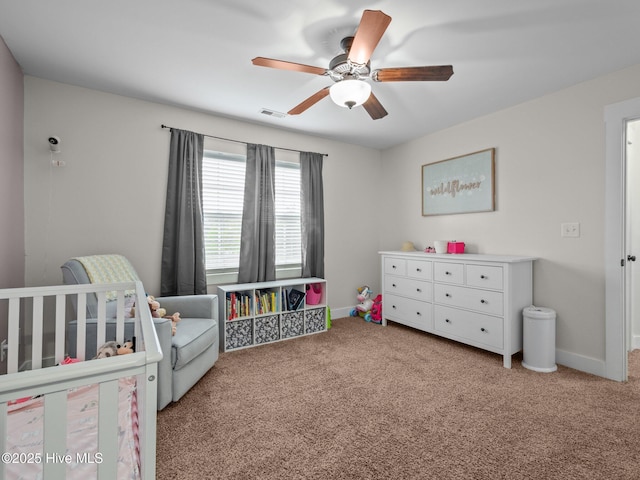 bedroom featuring carpet floors, baseboards, a ceiling fan, and a nursery area