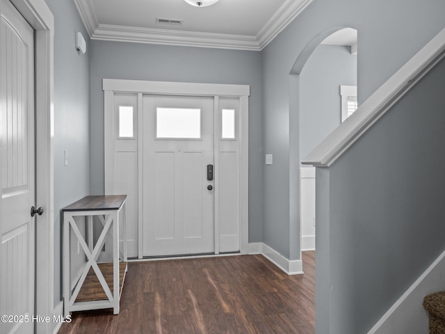 entryway with ornamental molding, dark wood-style flooring, arched walkways, baseboards, and stairs
