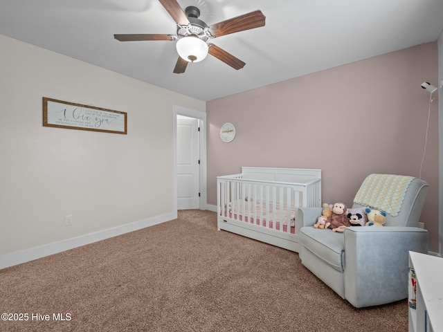 bedroom with carpet, a nursery area, baseboards, and ceiling fan