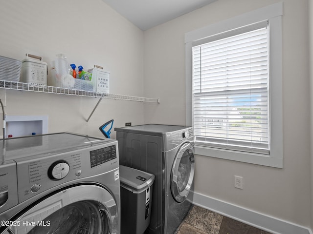 laundry area with washing machine and dryer and baseboards