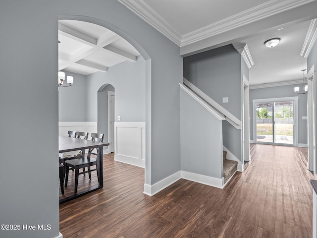 hall with arched walkways, beamed ceiling, dark wood-style flooring, crown molding, and stairway