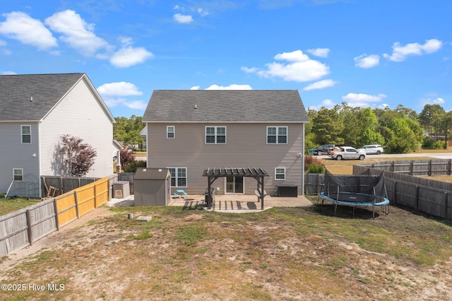 back of house featuring a patio, a trampoline, and a pergola