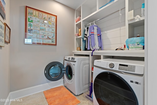 washroom with independent washer and dryer and baseboards