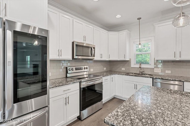 107 Meadowview Pl, Whispering Pines, NC 28327 - kitchen featuring appliances with stainless steel finishes, white cabinets, light wood finished floors, tasteful backsplash, and crown molding