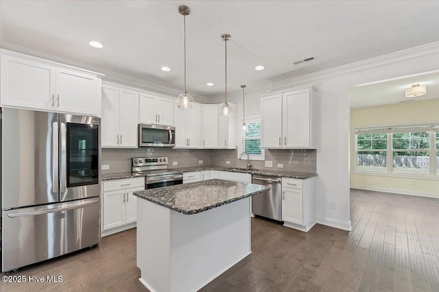 107 Meadowview Pl, Whispering Pines, NC 28327 - kitchen featuring stainless steel appliances, white cabinetry, plenty of natural light, ornamental molding, and recessed lighting
