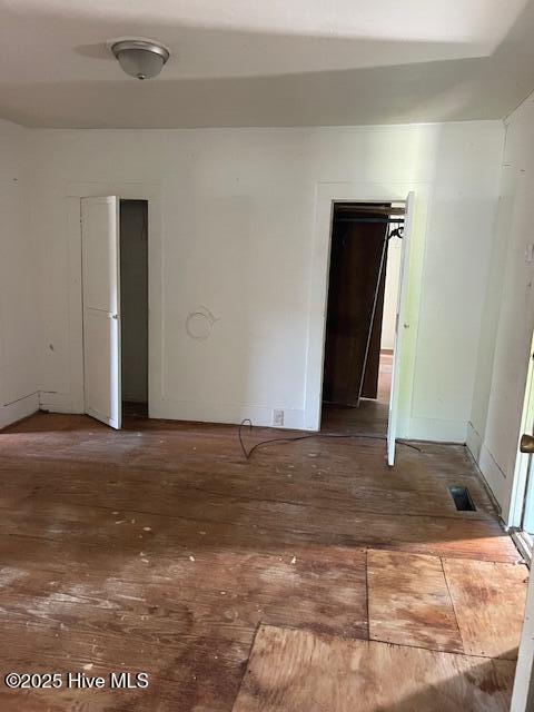 unfurnished room with hardwood / wood-style flooring and baseboards