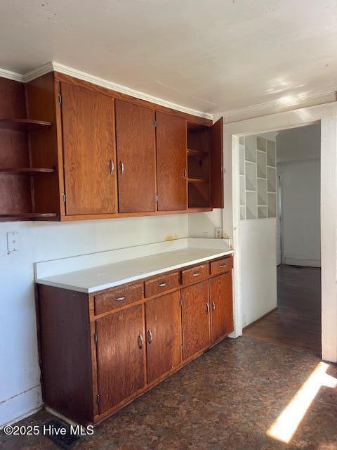kitchen with open shelves, brown cabinetry, and light countertops