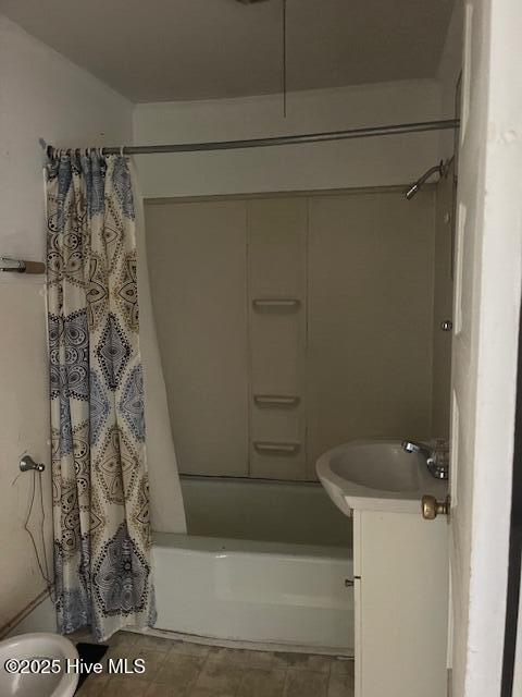 full bathroom with shower / tub combo with curtain, toilet, and a sink