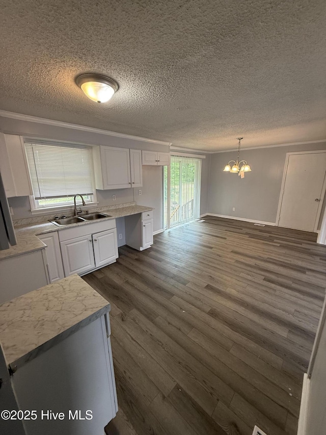 kitchen featuring a sink, white cabinetry, a chandelier, dark wood finished floors, and a textured ceiling