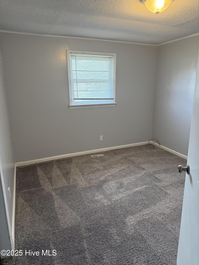 carpeted spare room with a textured ceiling and baseboards