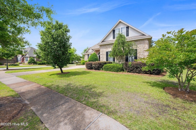 view of front of home with brick siding and a front yard