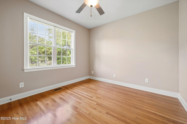 spare room with light wood-type flooring, baseboards, and ceiling fan