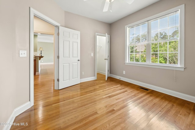 unfurnished bedroom featuring light wood-type flooring, baseboards, and ceiling fan
