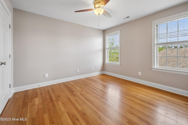spare room with light wood-style flooring, ceiling fan, and baseboards