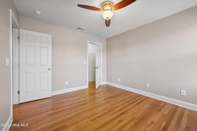 unfurnished bedroom featuring light wood-style flooring, baseboards, and a ceiling fan