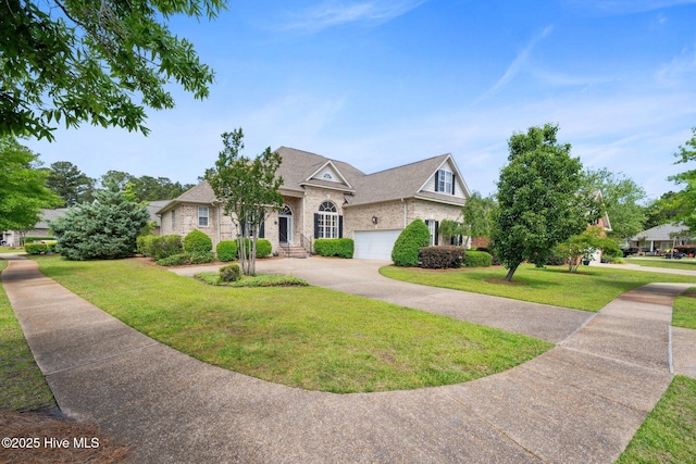 view of front of home with an attached garage, a front lawn, driveway, and brick siding