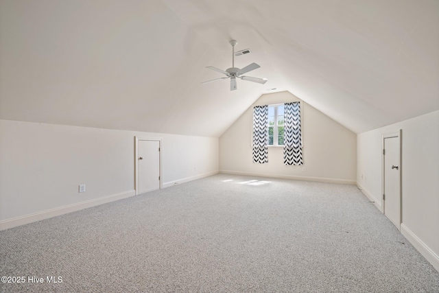 additional living space featuring vaulted ceiling, baseboards, carpet flooring, and a ceiling fan