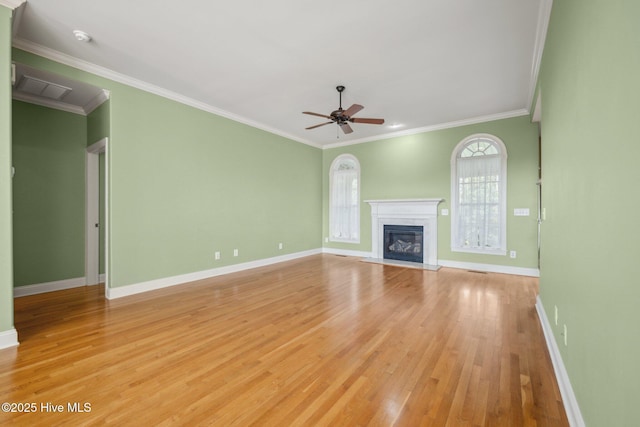 unfurnished living room with baseboards, light wood-style floors, ceiling fan, ornamental molding, and a fireplace with flush hearth