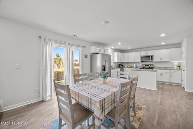 dining space with light wood-type flooring, baseboards, and recessed lighting